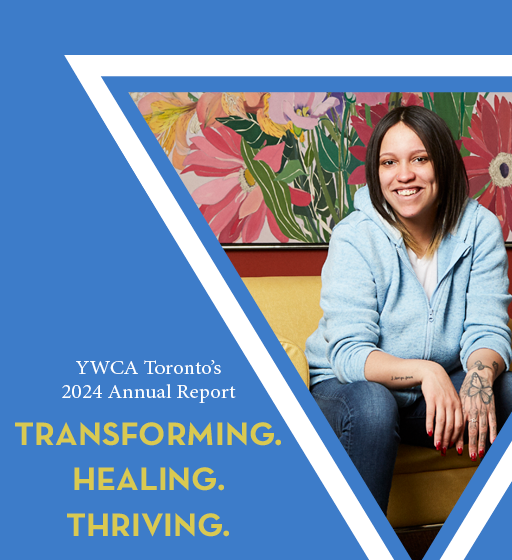 Woman sitting and smiling in front of painting of flowers.