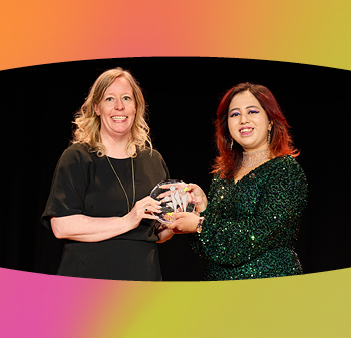 Two women holding award - one presenting it to the other